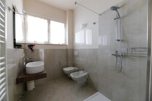 A modern bathroom with a glass shower enclosure, a toilet, a bidet, and a sink. - Margherita - Open Space Lake View Apartment with Lake View, Wi-Fi, and Air Conditioning (Sirmione)