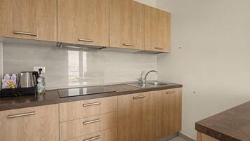 A kitchen with wooden cabinets, a stainless steel sink, and a countertop with various items.
