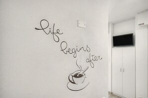 Eine Wand mit einem motivierenden Zitat und einer Kaffeetassen-Illustration.