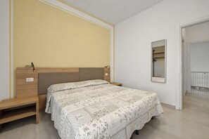 A bedroom with a bed, bedside tables, a wardrobe, and a mirror. - Peonia Apartment – Lake View Three-Room with Lake View, Wi-Fi, and Air Conditioning (Sirmione)
