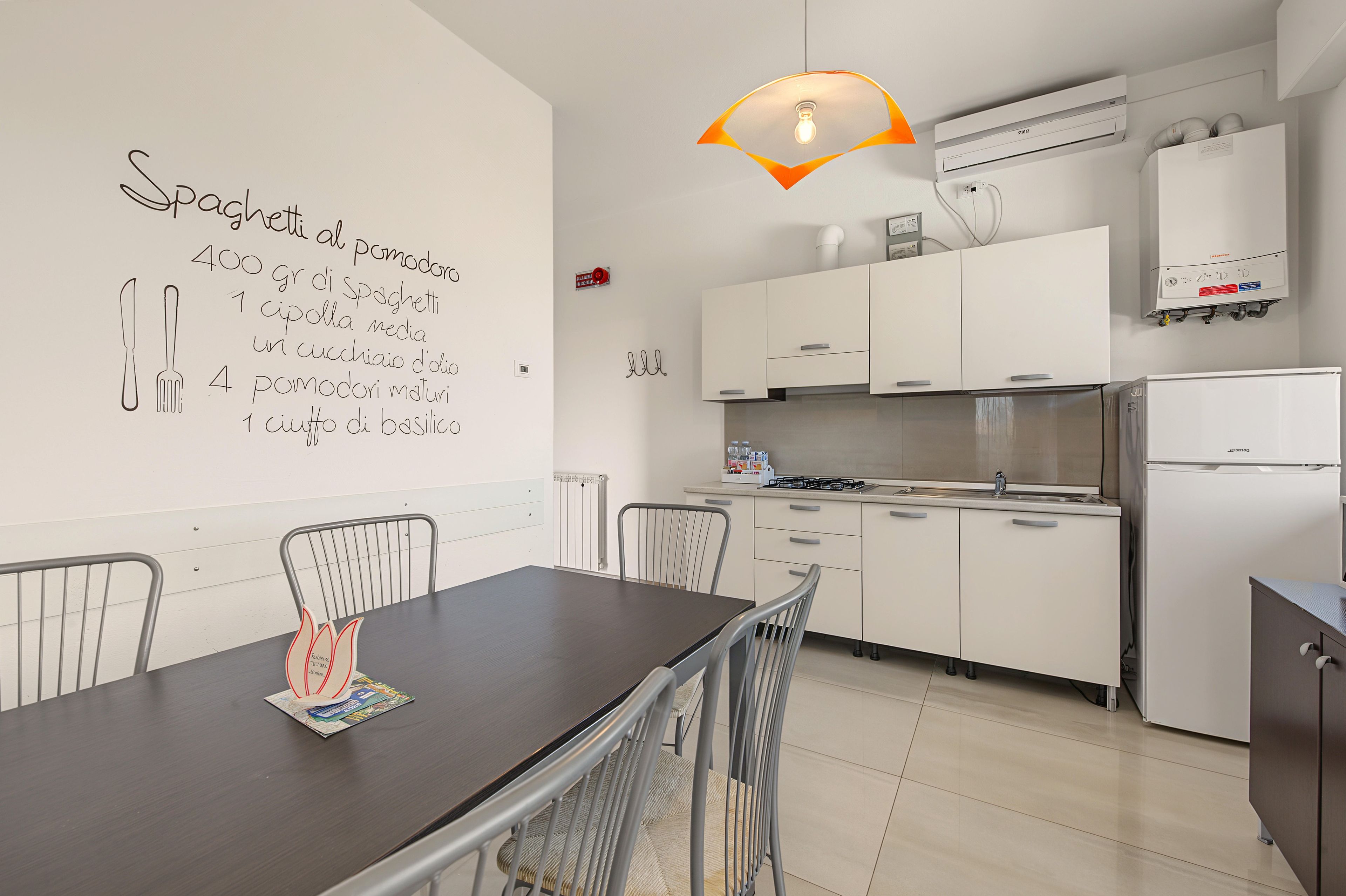 A modern kitchen with white cabinets, a gas stove, and a dining table with chairs.