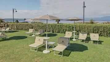 Una terrazza con posti a sedere all'aperto e ombrelloni, con vista su un corpo d'acqua.