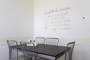 Sala de conferências com quadro branco mostrando receita de espaguete.