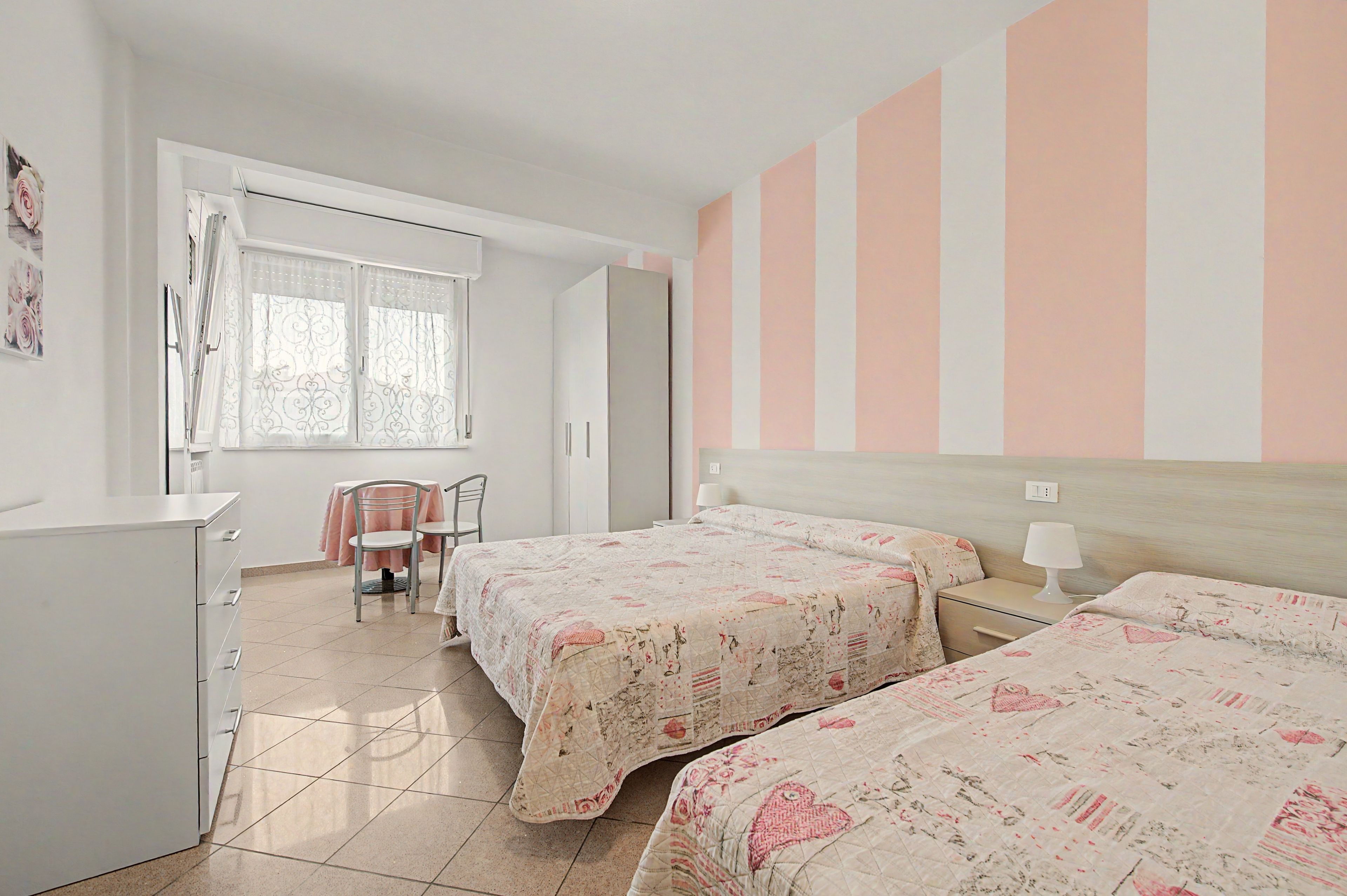 Una camera da letto con due letti, una scrivania e una sedia.