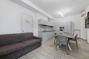 A modern kitchen with grey cabinets, a built-in oven, and a microwave. - Ninfea Apartment – Superior Four-Room with Shared Pool, WiFi, and Air Conditioning (Sirmione)