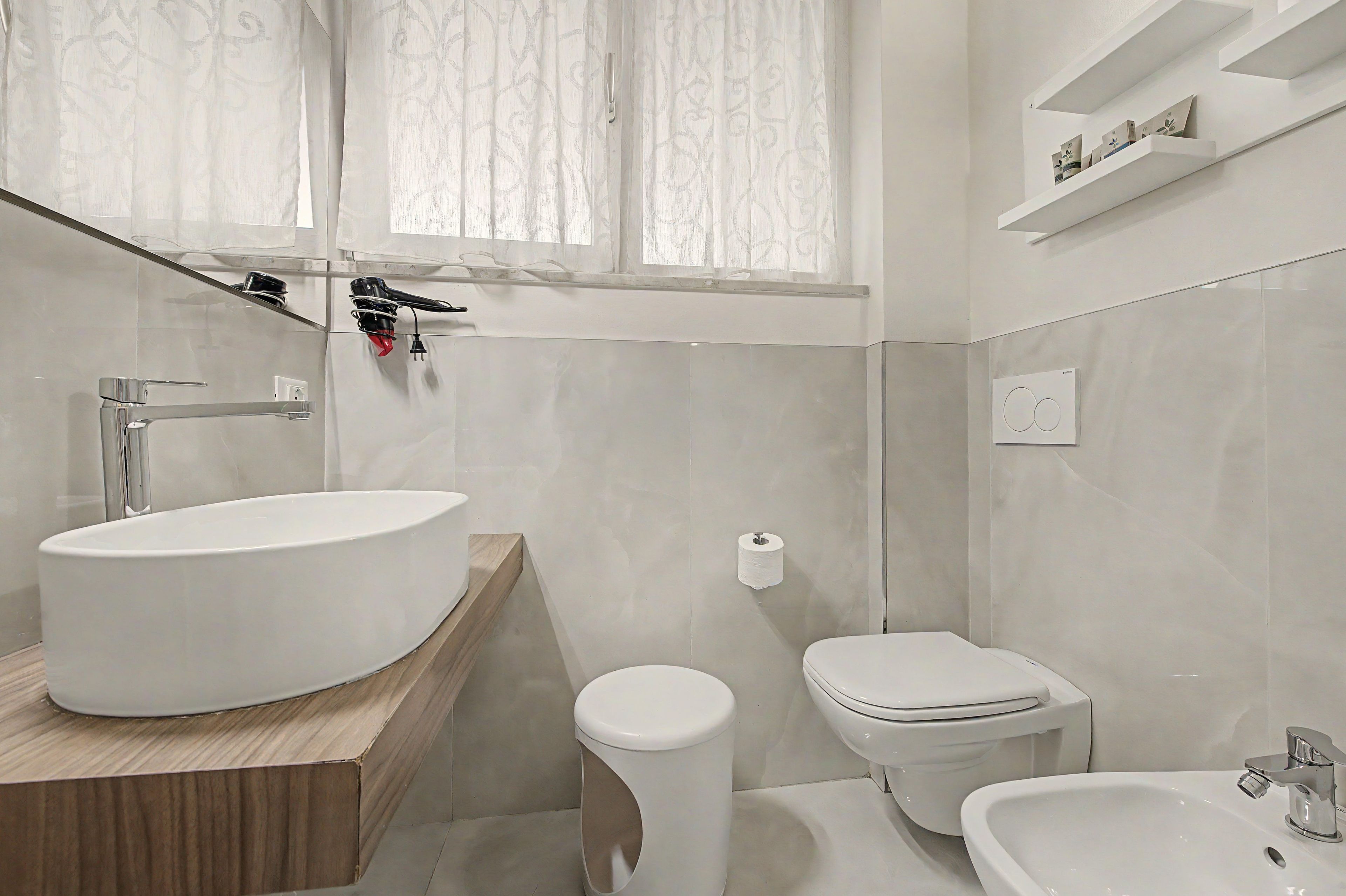 Un bagno moderno con un lavabo ovale, un water e un bidet.