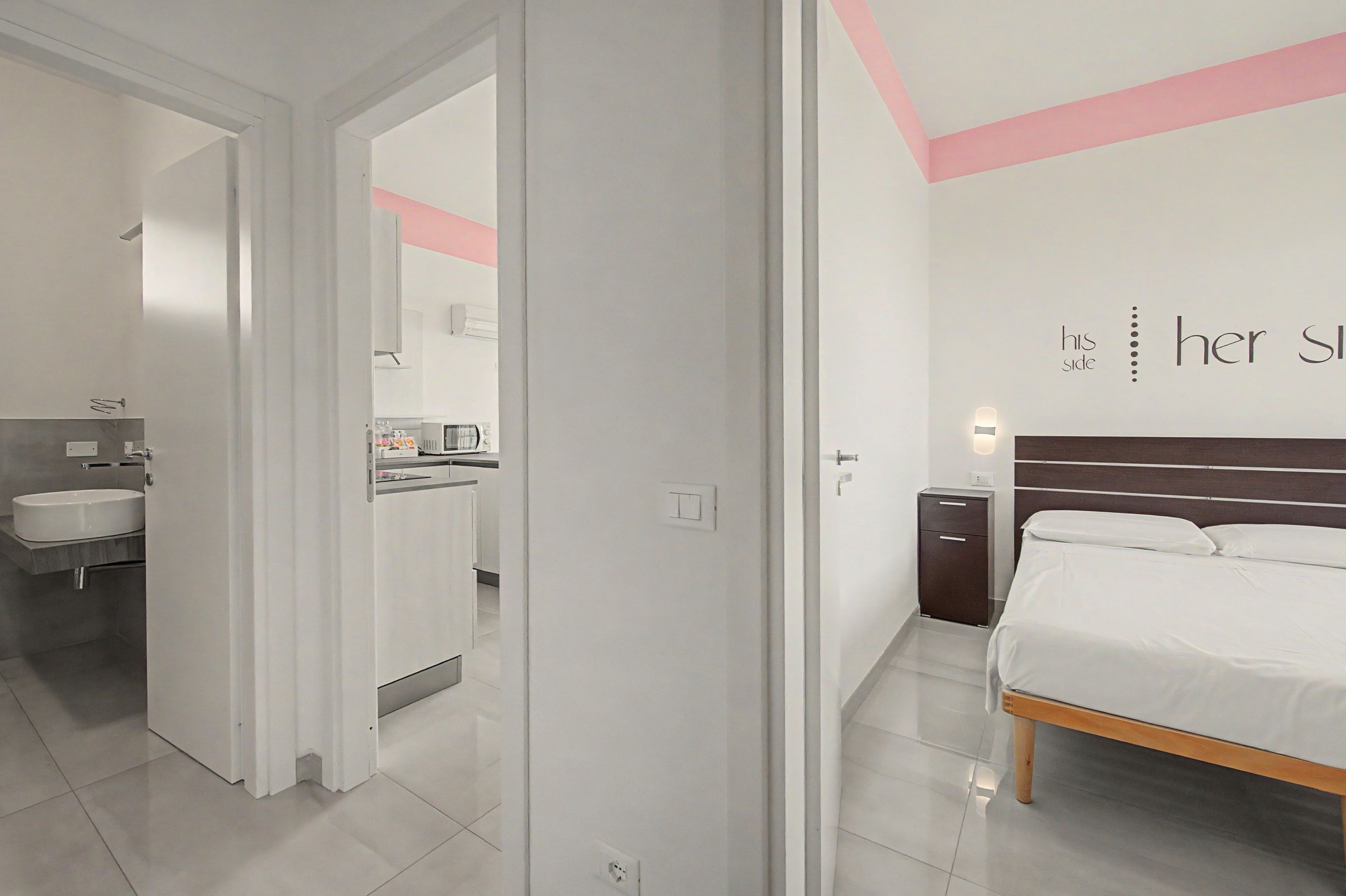 Une chambre à coucher moderne avec un lit, une table de chevet et une lampe fixée au mur.