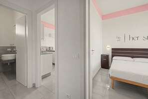 A modern bedroom with a bed, bedside table, and a wall-mounted light. - Apartment 'Ibisco - Bilocale Vista Lago' with Lake View, Wi-Fi and Air Conditioning (Sirmione)