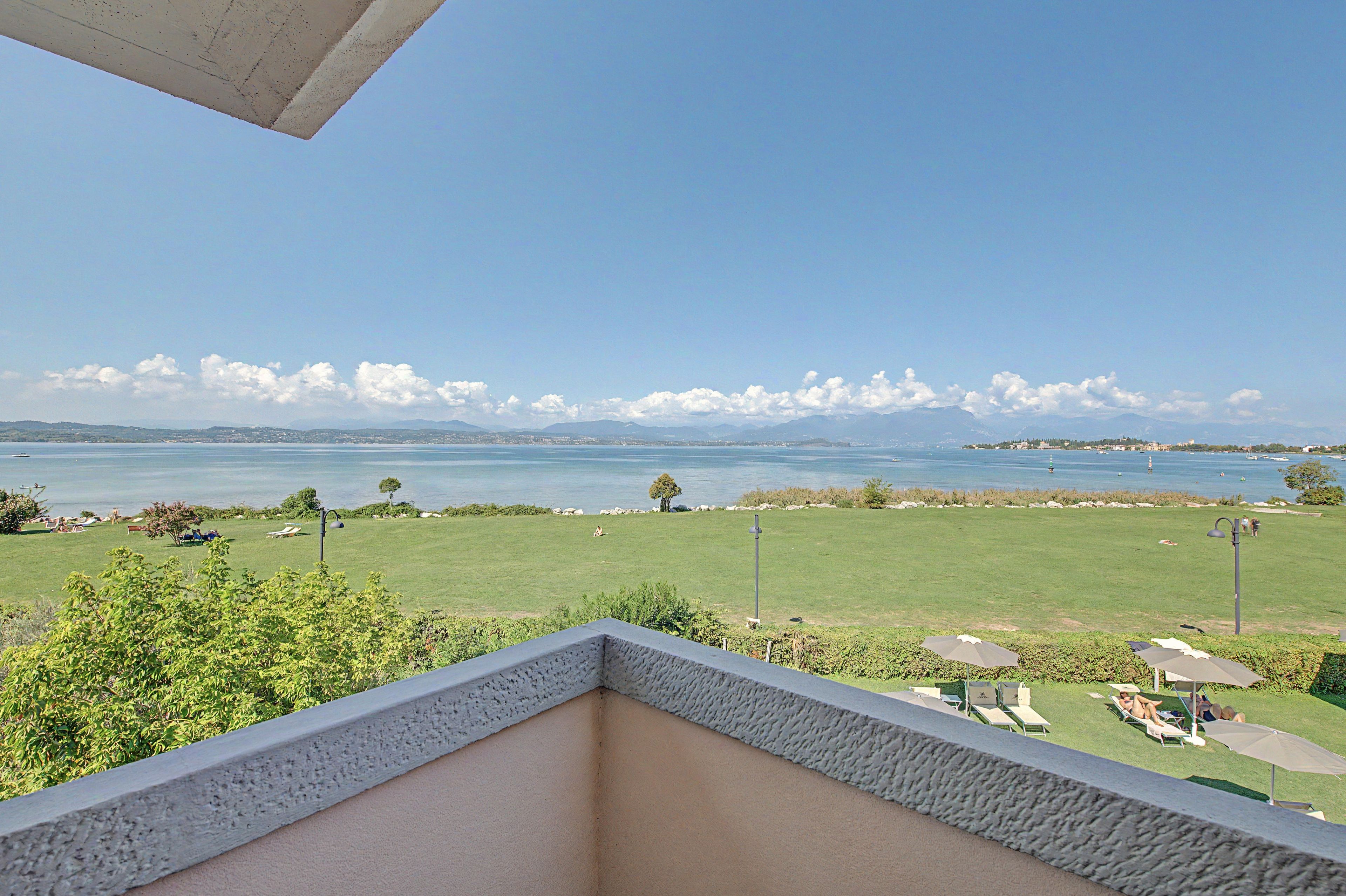 Ein Balkon mit Blick auf einen See und ferne Berge.