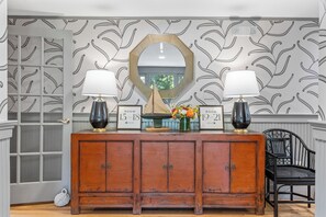 Un meuble en bois avec deux lampes, un miroir et des panneaux indiquant le numéro des chambres.