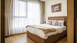 Ein Schlafzimmer mit einem großen Bett, Vorhängen, einem Gemälde und Holzböden.
