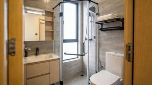 Une salle de bain moderne avec une douche à parois de verre, un lavabo et des toilettes.