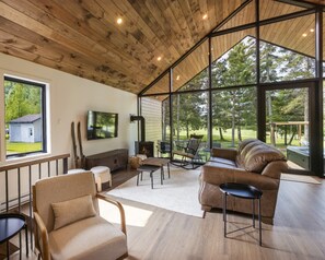 Un salón amplio con un ventanal grande, una chimenea y una zona de estar confortable.