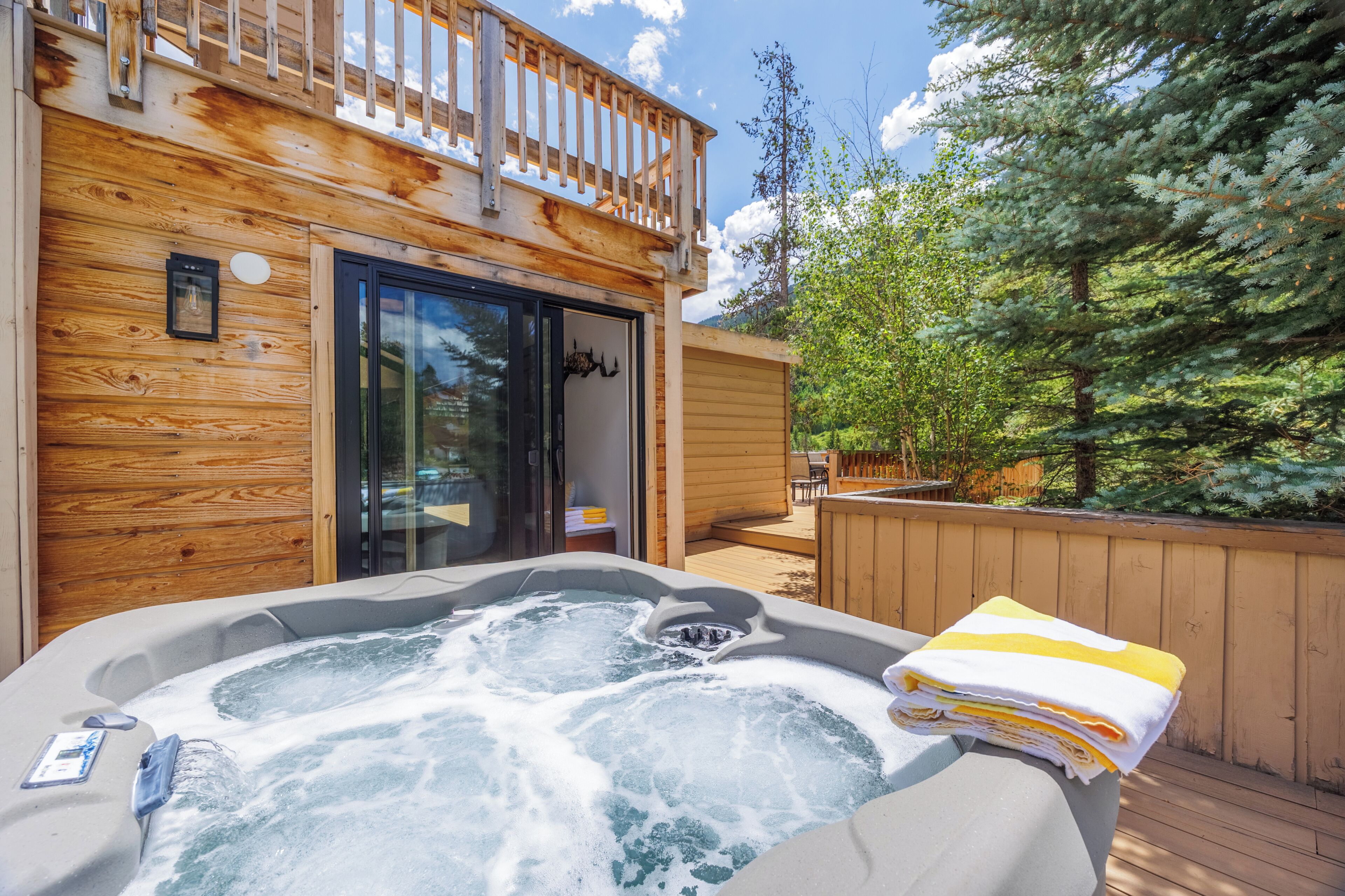 Una cabaña de madera con jacuzzi y terraza.