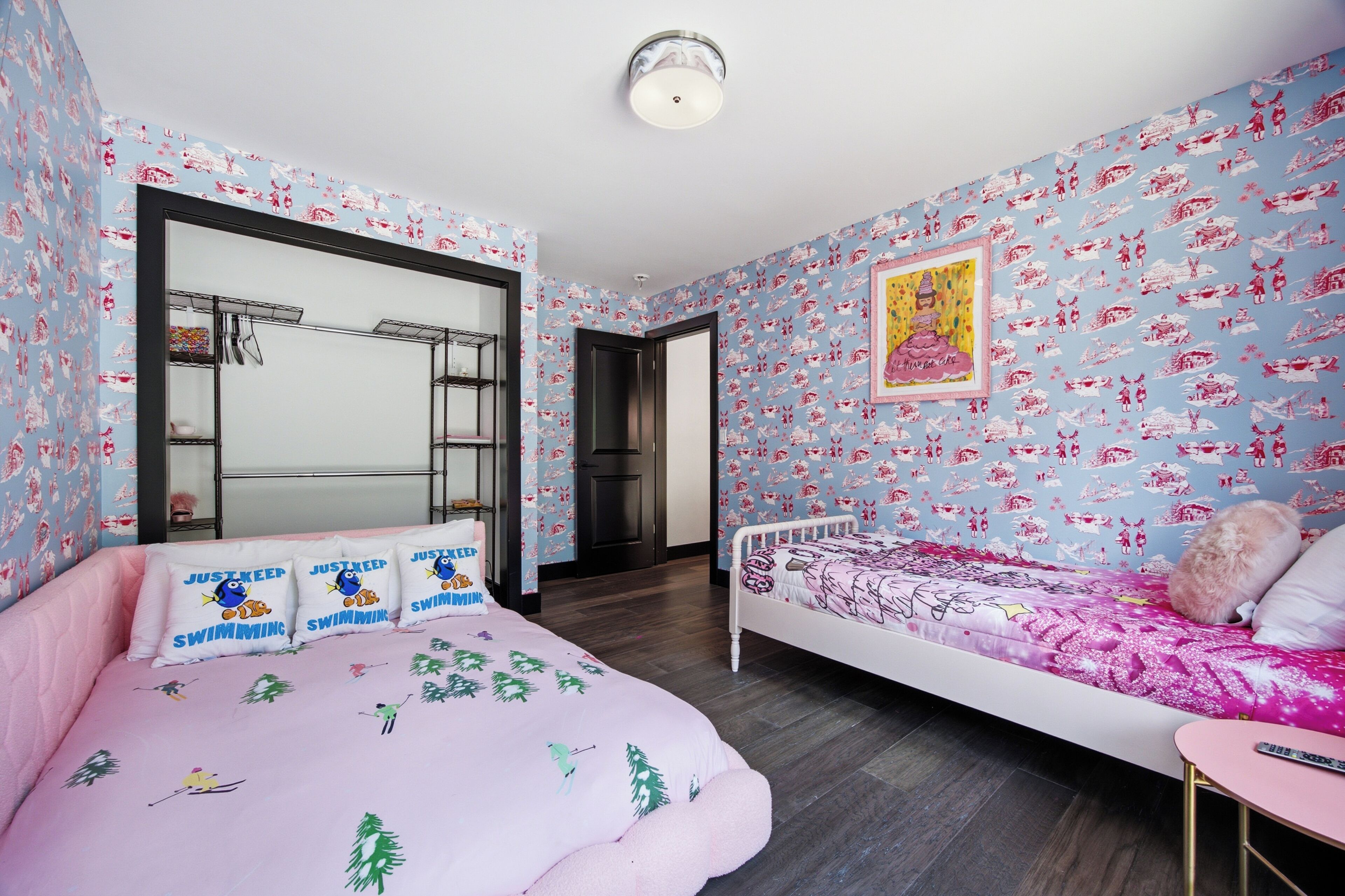 A bedroom with a bed, a chair, a small table, and a wardrobe.