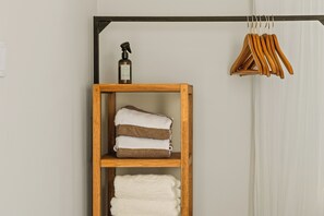 A wooden shelf with folded towels and a spray bottle. - Casa Atardi – Your tropical home away from home in Curaçao (Willemstad)