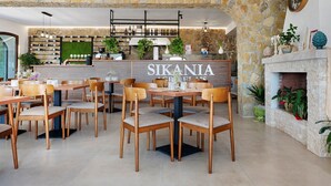 A restaurant interior with stone walls, wooden tables and chairs, a bar area, and a fireplace. - A Schietta Room – Sikania Agrirelais, Mountain View (Caccamo)