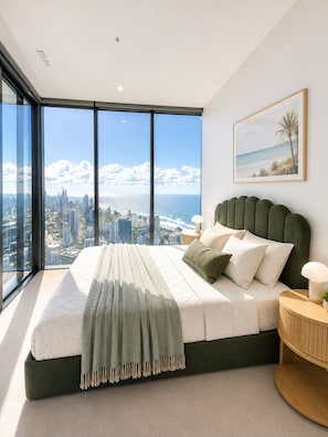 A high-rise bedroom with a city view, a large bed, and a nightstand. - Sage Above the Sea - Ocean Views (Broadbeach)