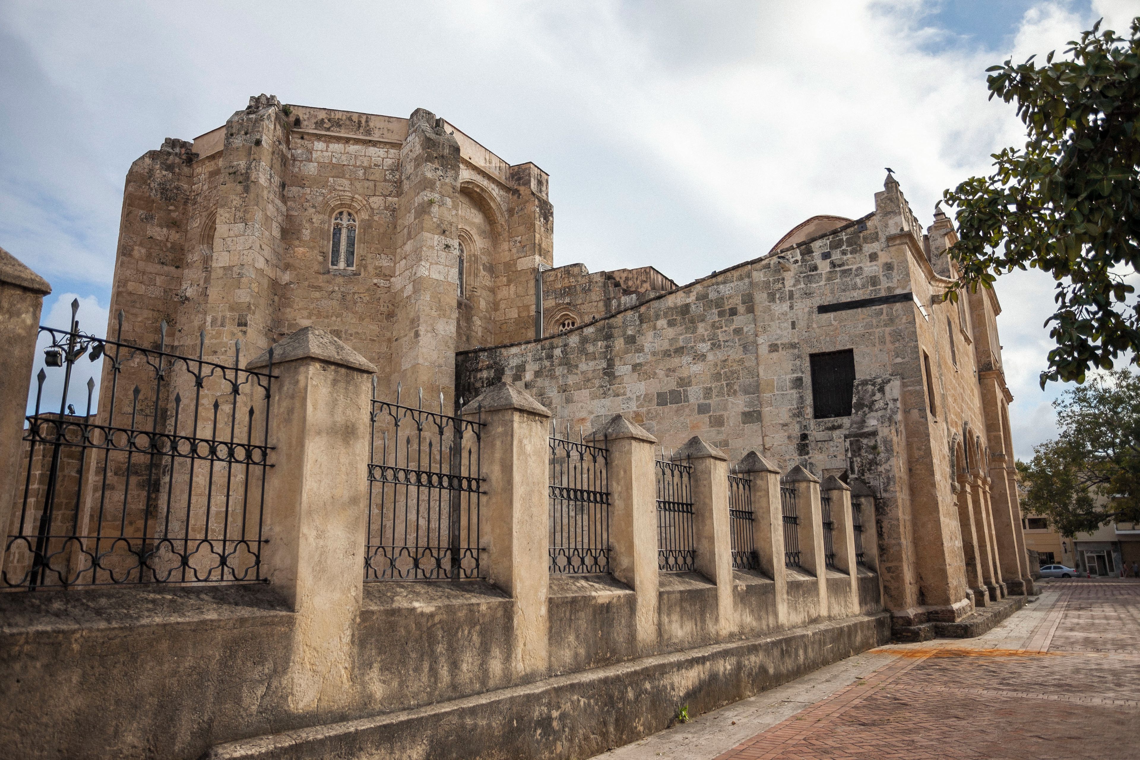 A historic stone building with a fortified entrance, featuring a series of columns and a gate.