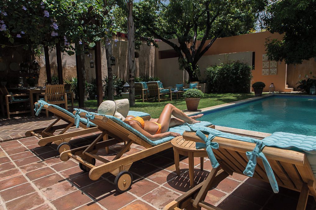 A poolside area with lounge chairs and a person relaxing.