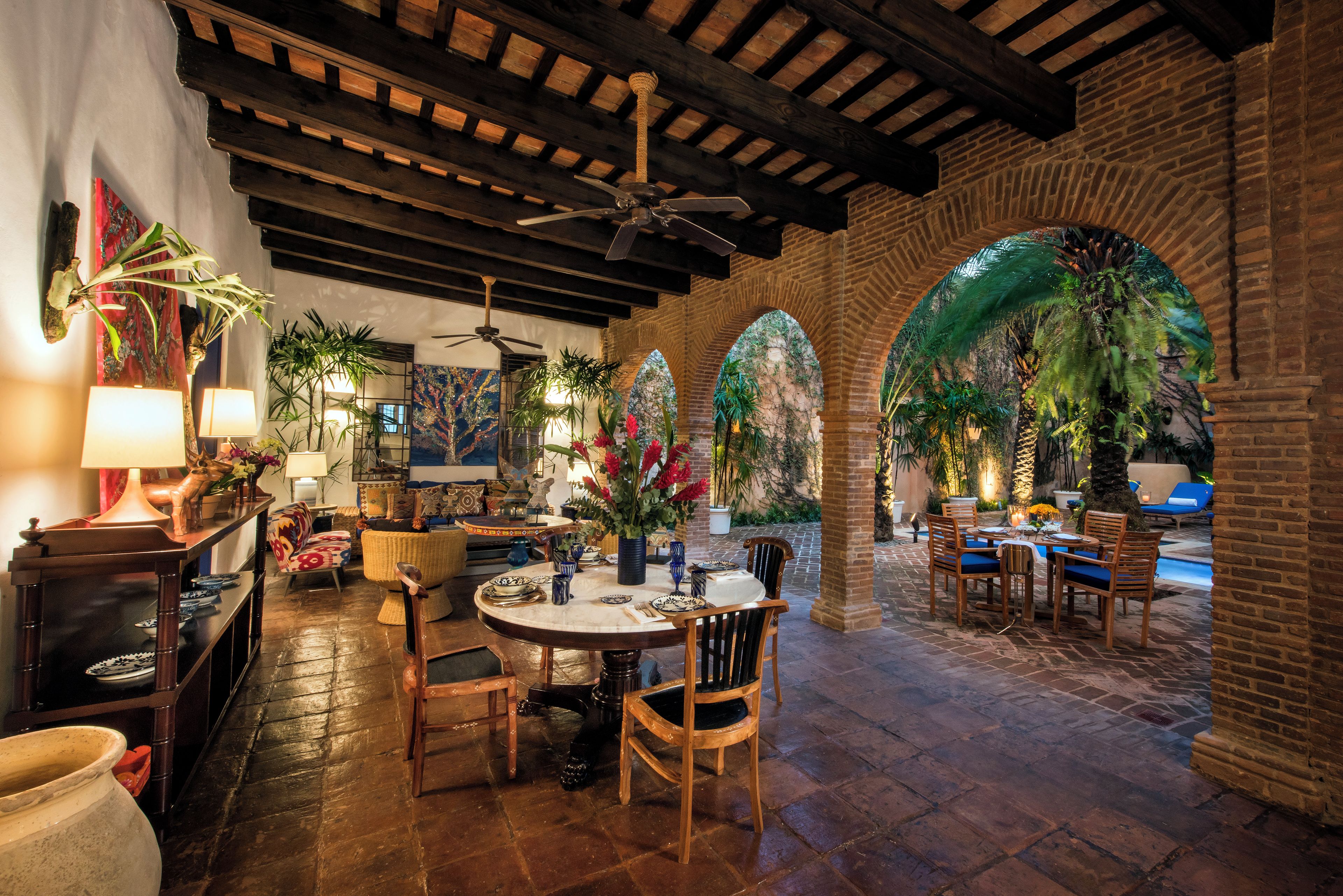 A restaurant with a patio area featuring brick arches and a pool.