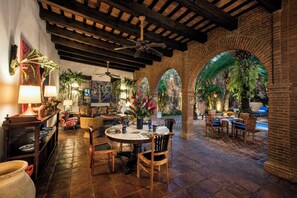 A restaurant with a patio area featuring brick arches and a pool.