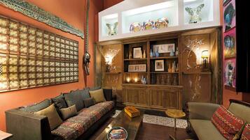 A cozy living room with a sofa, a coffee table, and a bookshelf.