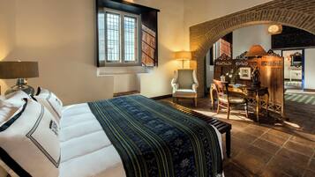 Ein Hotelzimmer mit Bett, Stuhl, Schreibtisch und Blick auf einen Außenbereich.