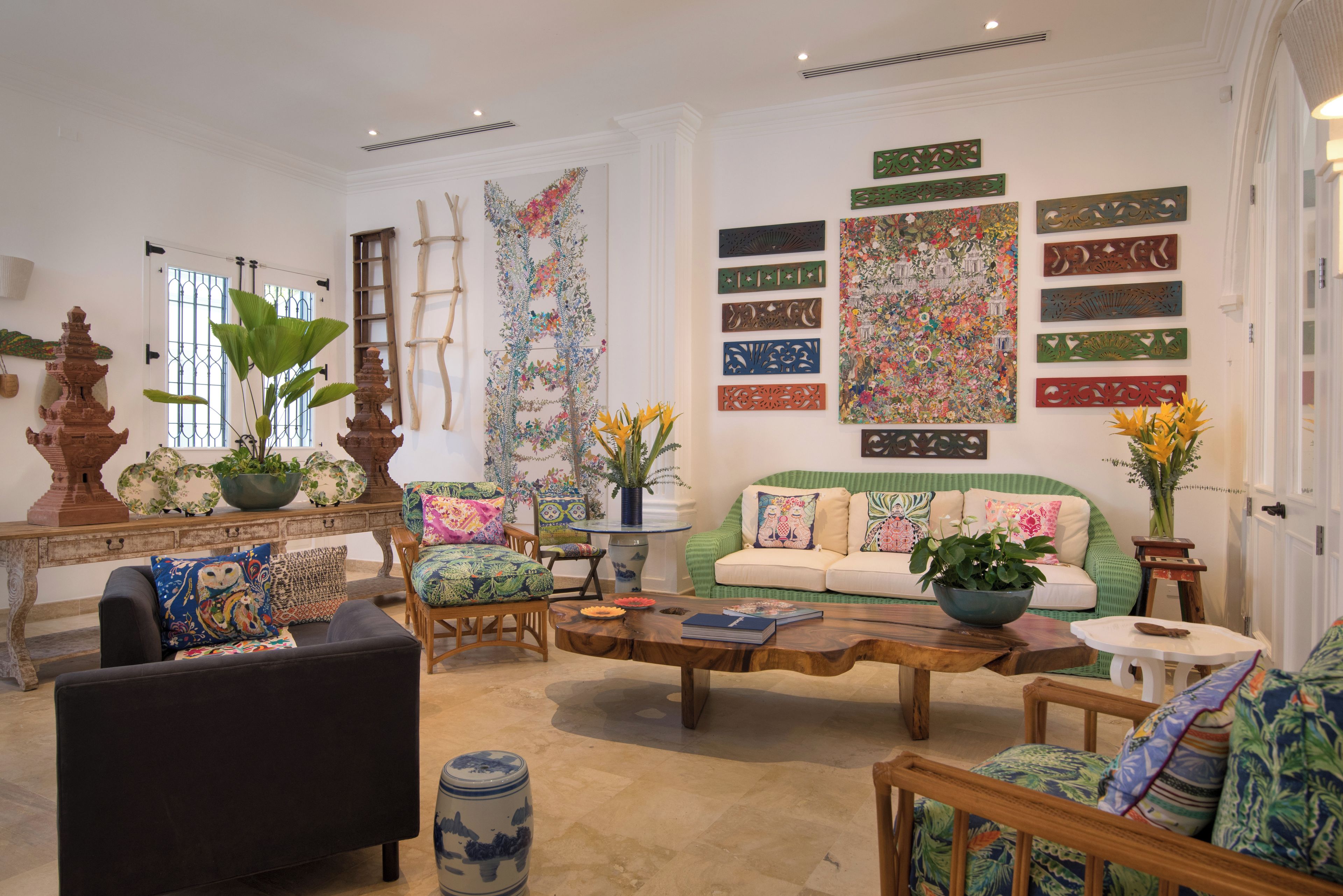 Una sala de estar bien amoblada con un sofá, sillones, una mesa de centro y objetos decorativos.