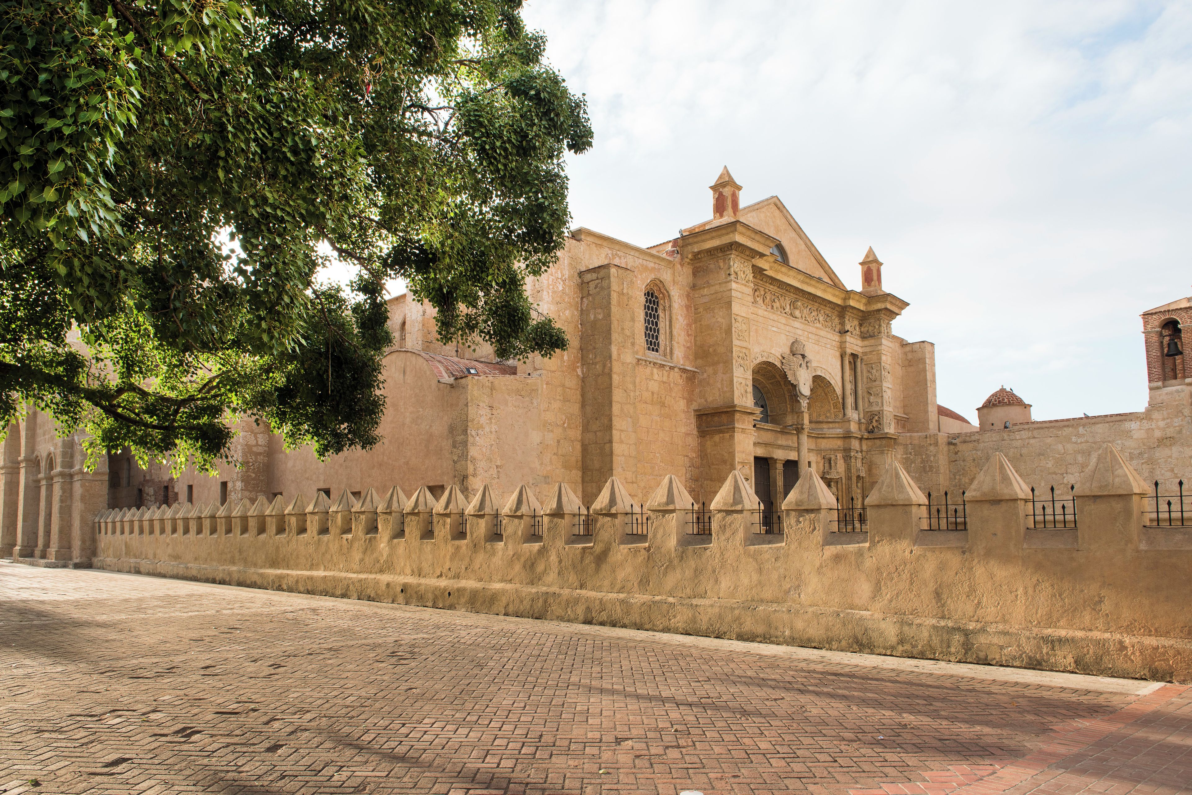 A historic building with a stone facade, arched windows, and a crenellated wall.