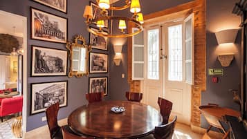Un coin repas avec une table ronde, des chaises et des tableaux encadrés accrochés aux murs.