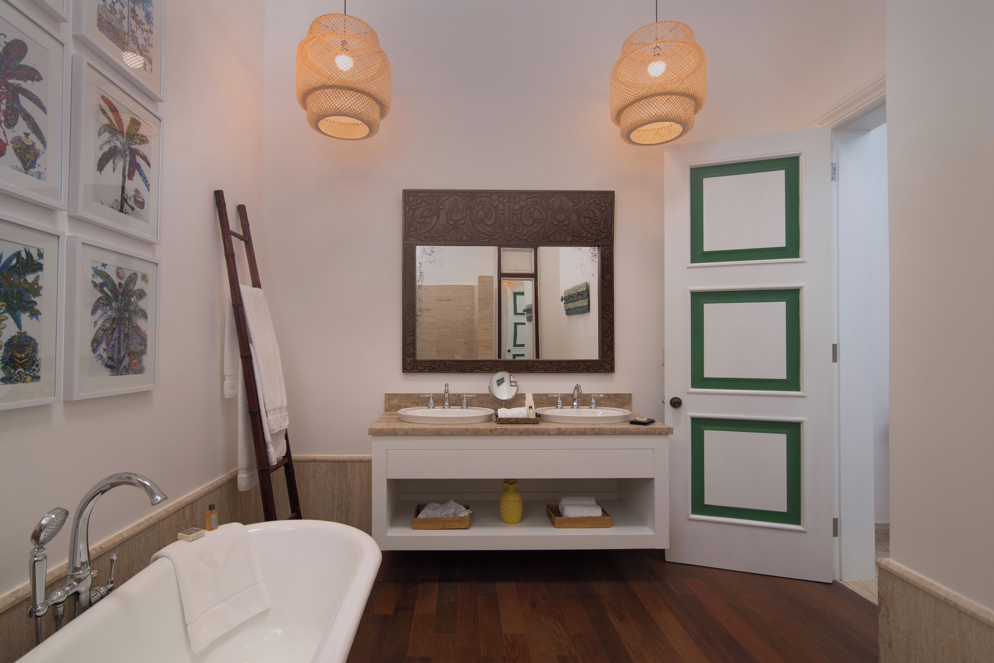 Un baño con una bañera blanca, un lavamanos con un espejo encima y dos luces empotradas.