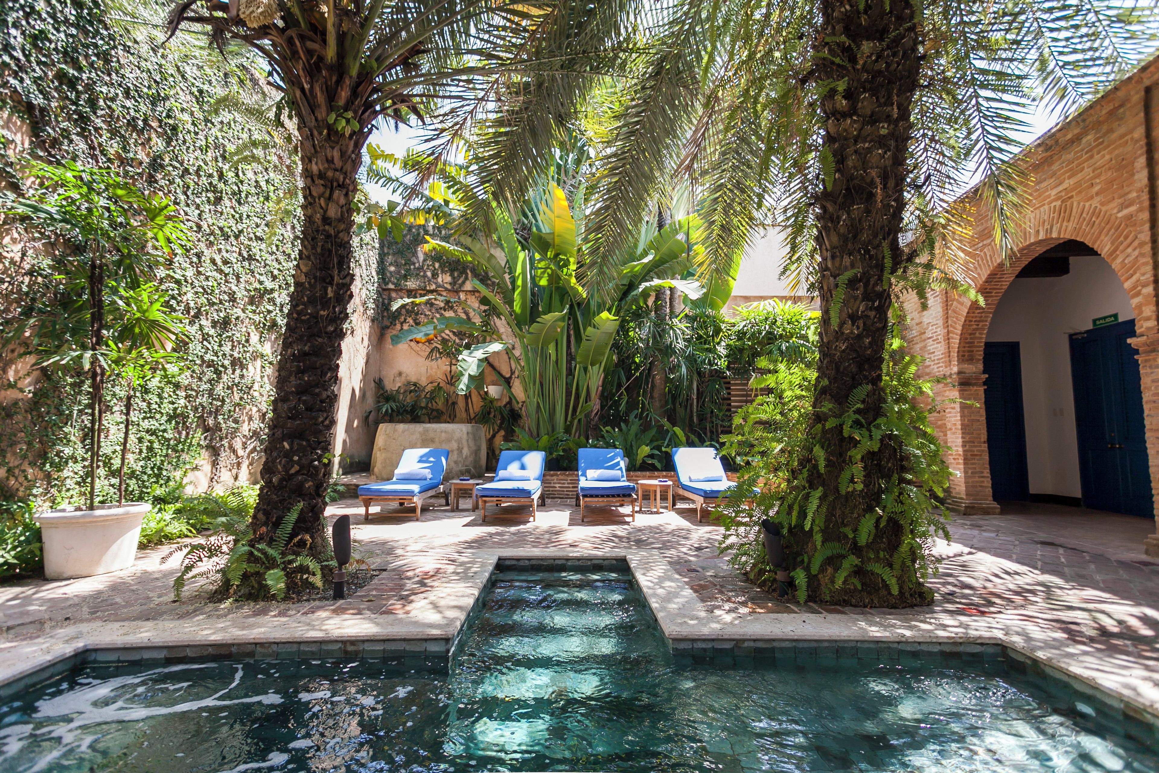 A pool area with lounge chairs and a small water feature.