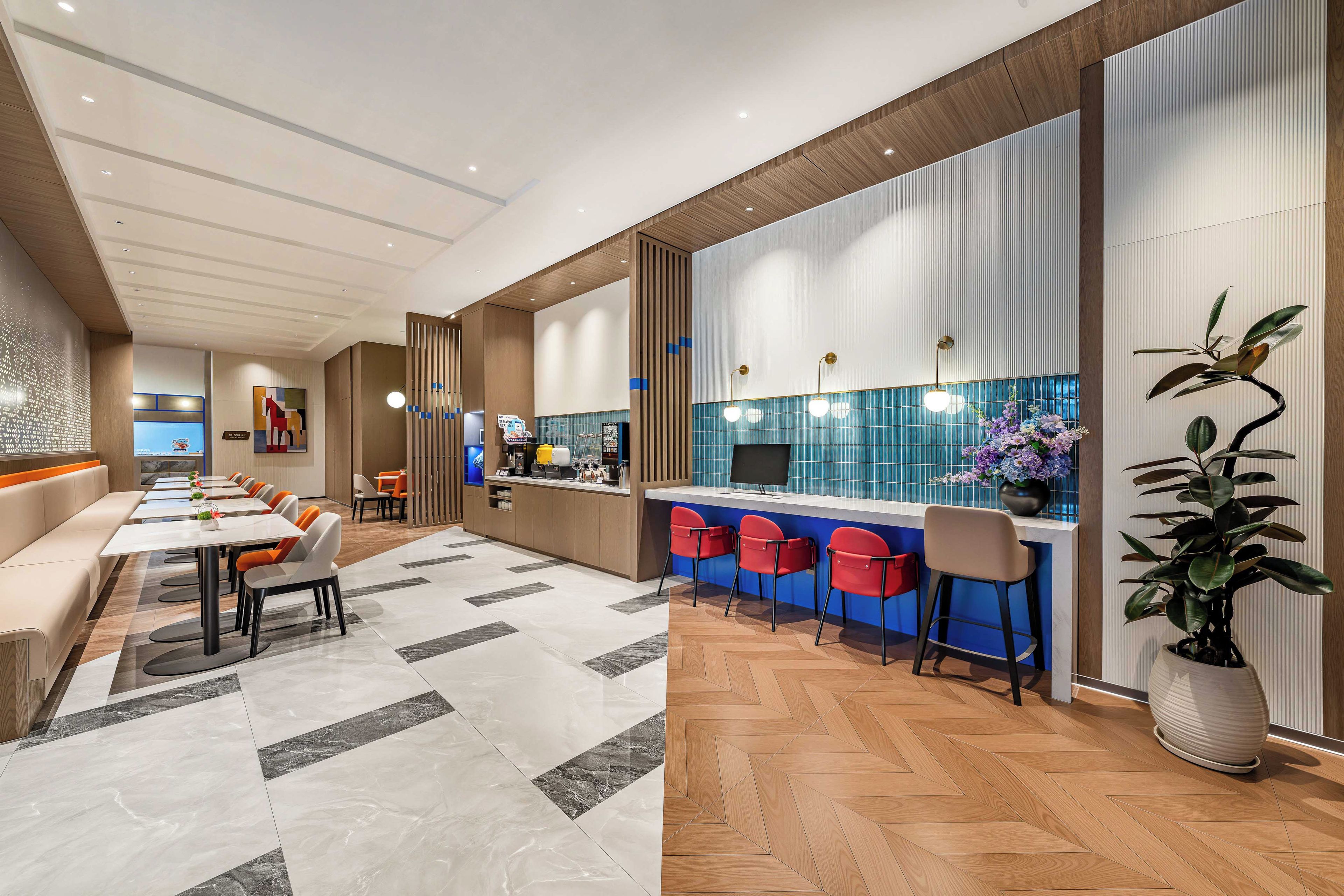 Eine moderne Hotelhalle mit einer langen Rezeption, einer Sitzecke und einer Bar.