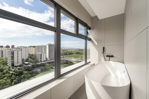 A modern bathroom with a large window, a bathtub, and a view of a cityscape. - Holiday Inn Express Beijing Daxing Xihongmen By Ihg (Beijing)