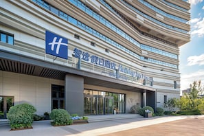 Un edificio de hotel moderno con una señalización destacada que dice 'Holiday Inn Express' y un logotipo con una 'H' azul.