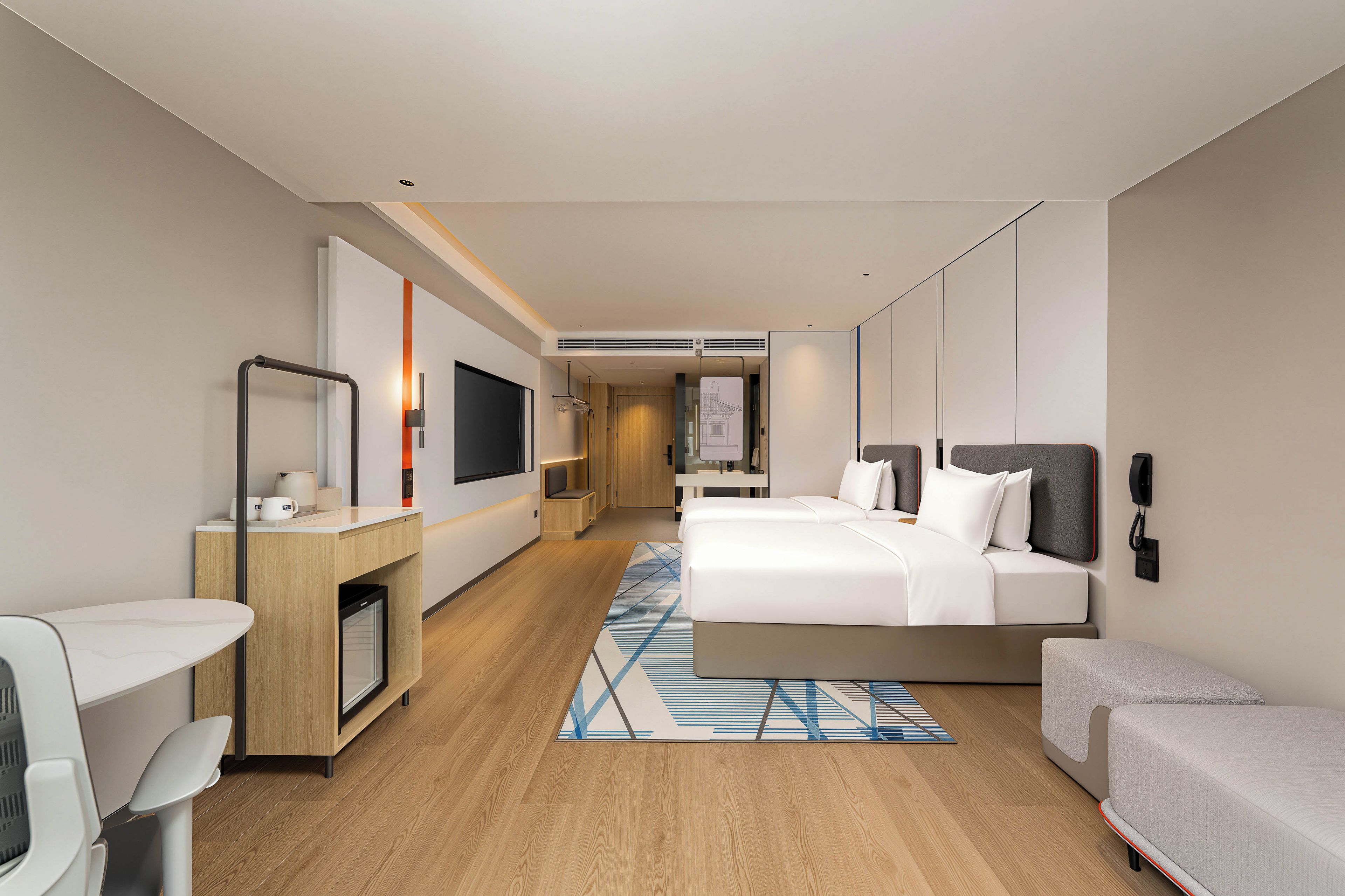 Una habitación de hotel moderna con cama, mesitas de noche, escritorio, silla, televisor y baño.