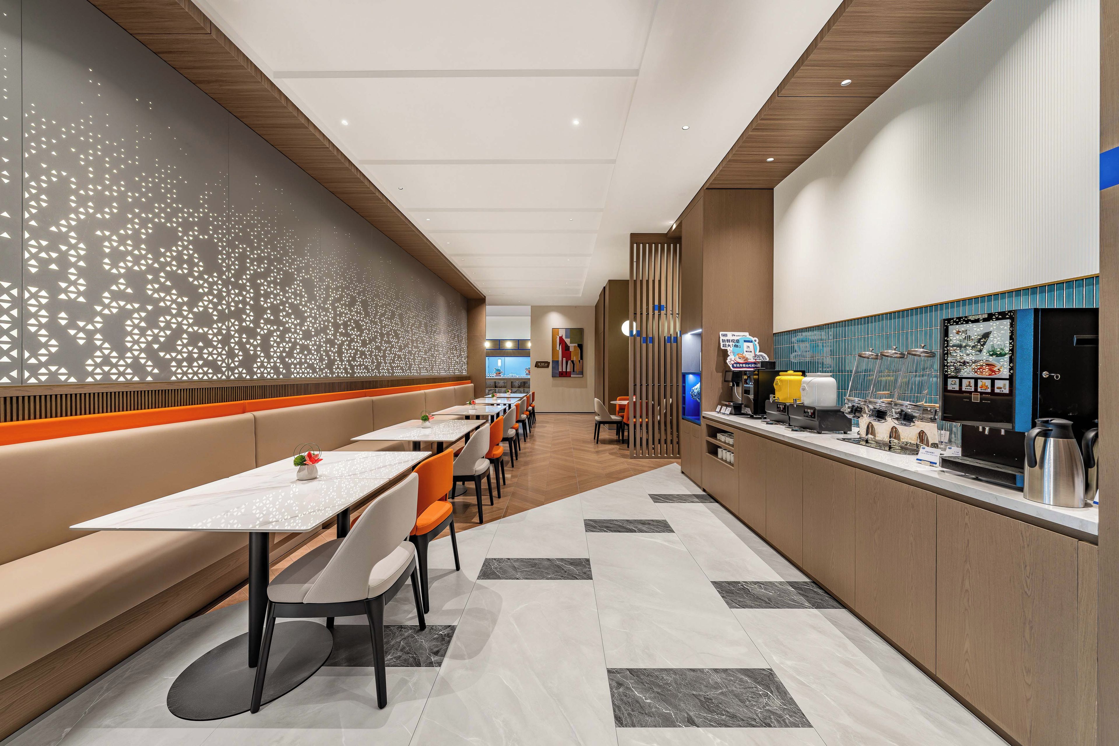 Un restaurant moderne avec de longues tables, des banquettes et un bar à café.