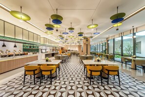 Un restaurante moderno con una barra larga, varias mesas y un suelo con diseño.