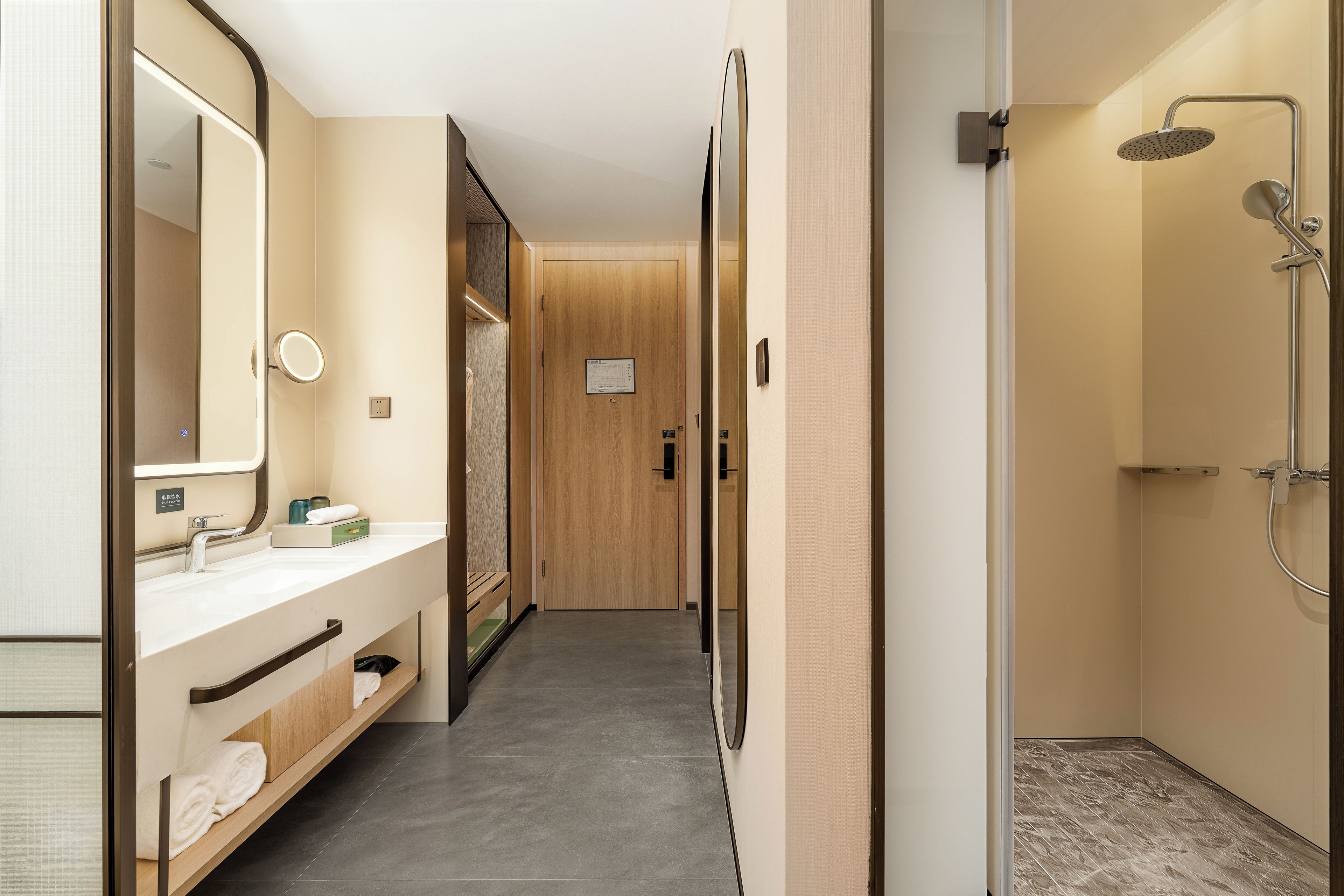 A modern bathroom with a shower, a vanity with a mirror, and a towel rack.