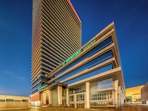 Un hôtel moderne, avec de nombreux étages et de grandes fenêtres.