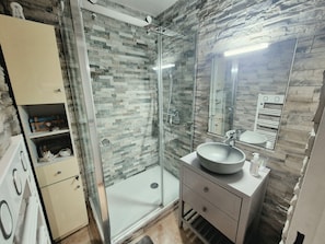 A bathroom with a glass-enclosed shower, a sink with a round basin, and a mirror above the sink. - Sea View Apartment with Terraces & Pools (Saint-Mandrier-sur-Mer)