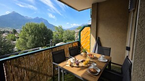 Ein Balkon mit einem Frühstückstisch, mit Blick auf eine Berglandschaft.