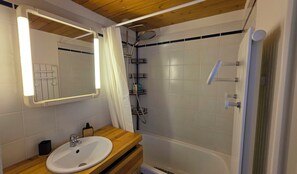 A bathroom with a sink, mirror, shower, and tiled walls. - Apartment "Le Col de Mélodies" with balcony (Briançon)