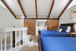 A bedroom with a bed, a desk, and a sliding barn door closet. - Updated 3 BR Chalet/Walk to Sugar Mountain Resort/ Hot tub/ Fireplace (Sugar Mountain)