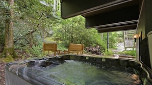 Ein Whirlpool in einem Garten mit Holzstühlen und einer Holzterrasse.