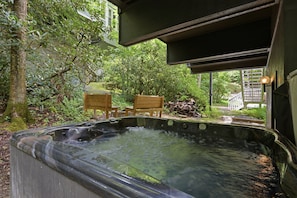 A hot tub in a garden with wooden chairs and a wooden deck. - Updated 3 BR Chalet/Walk to Sugar Mountain Resort/ Hot tub/ Fireplace (Sugar Mountain)
