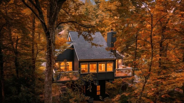 Ein Haus mit Balkon, umgeben von Bäumen.
