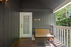 A porch with a bench, a door, and a 'WELCOME' sign. - Updated 3 BR Chalet/Walk to Sugar Mountain Resort/ Hot tub/ Fireplace (Sugar Mountain)