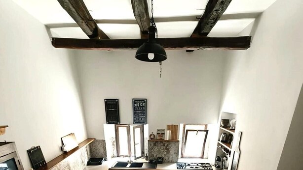 A compact kitchen with a dining area, wooden beams on the ceiling, and a view of the living area. - Apartment 'Civico 5' with Wi-Fi and Air Conditioning (Lamezia Terme)